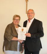 Bürgermeister Dr. Barth überreicht Ortsvorsteherin Lieselene Scherer ihre Ernennungsurkunde.